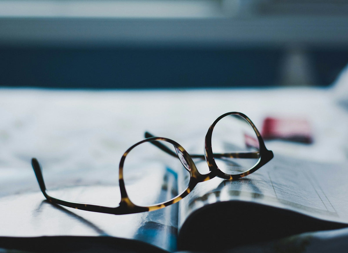 Tortoiseshell vintage-style sunglasses beside a magazine