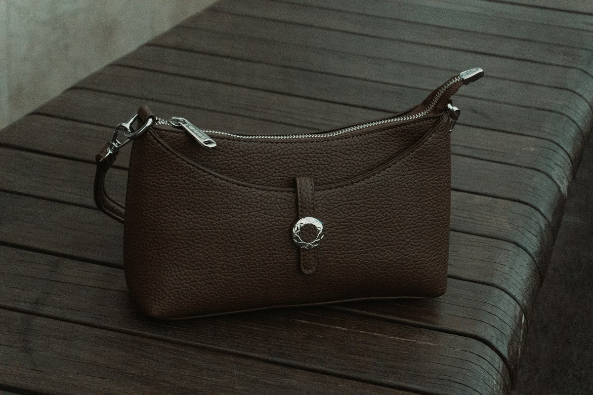 Brown vintage leather handbag on wood